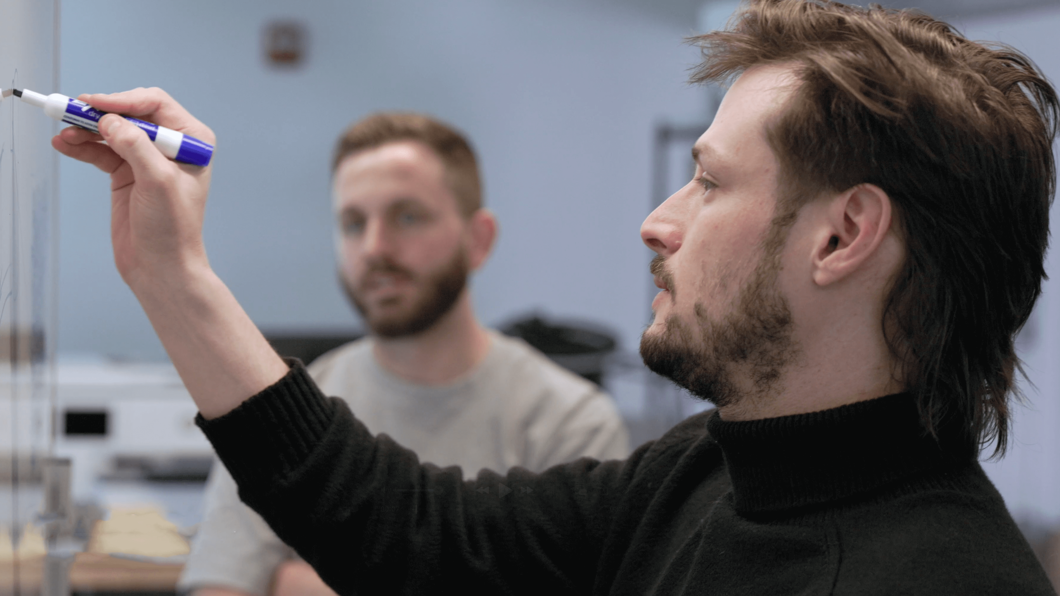 2 engineers in front of the board